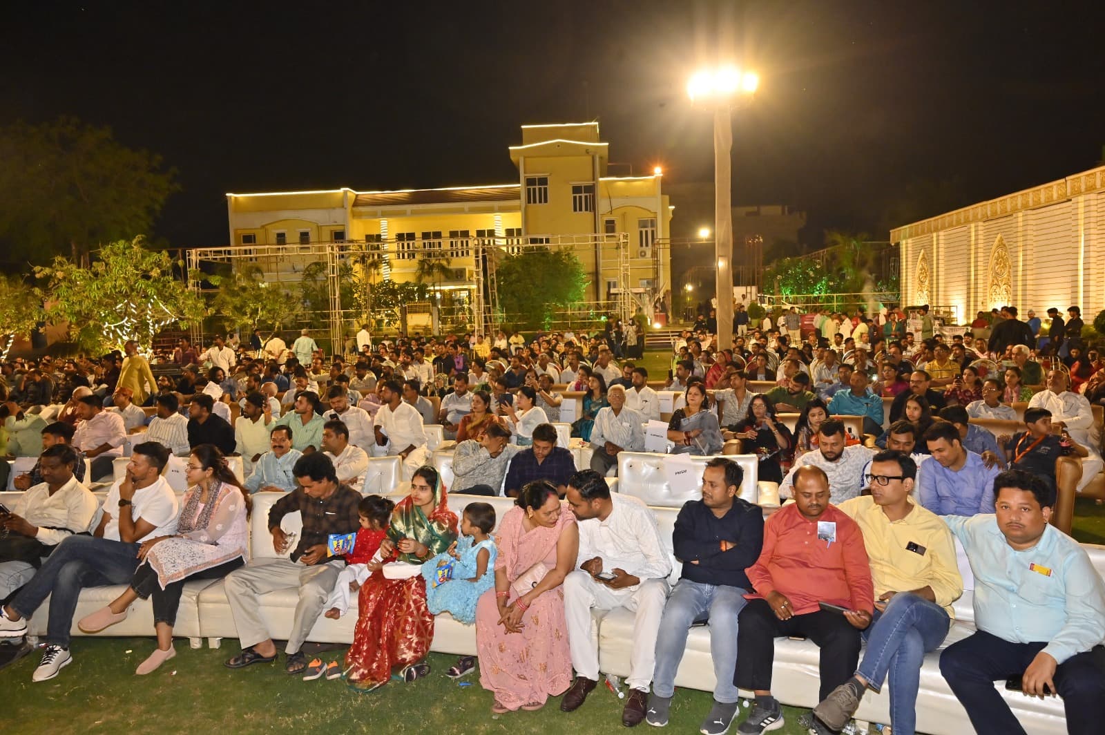 Guests seated outdoors for a cultural programme at Adarsh Vatika