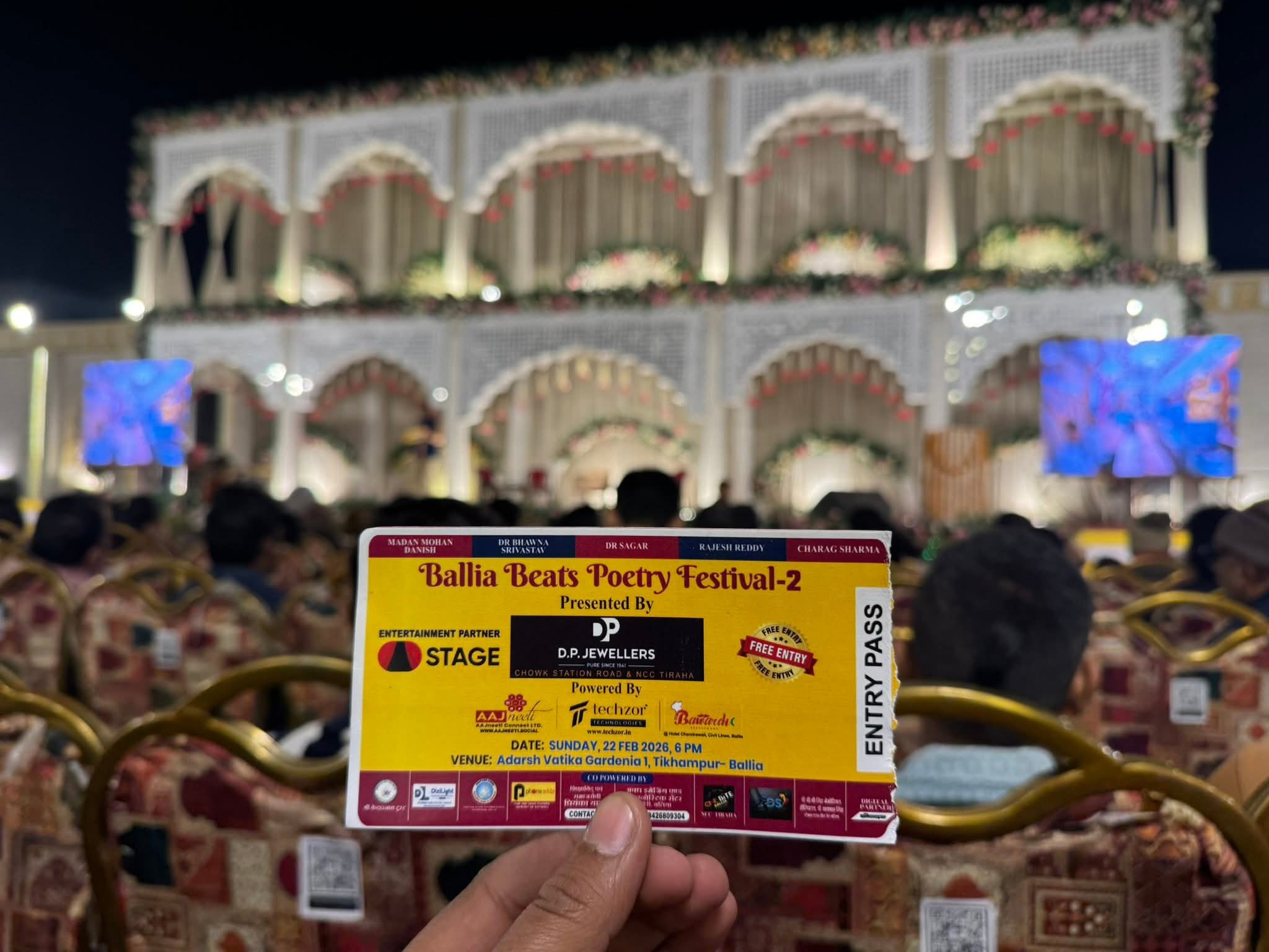 Ballia Beats Poetry Festival entry pass held in front of the event stage at Adarsh Vatika